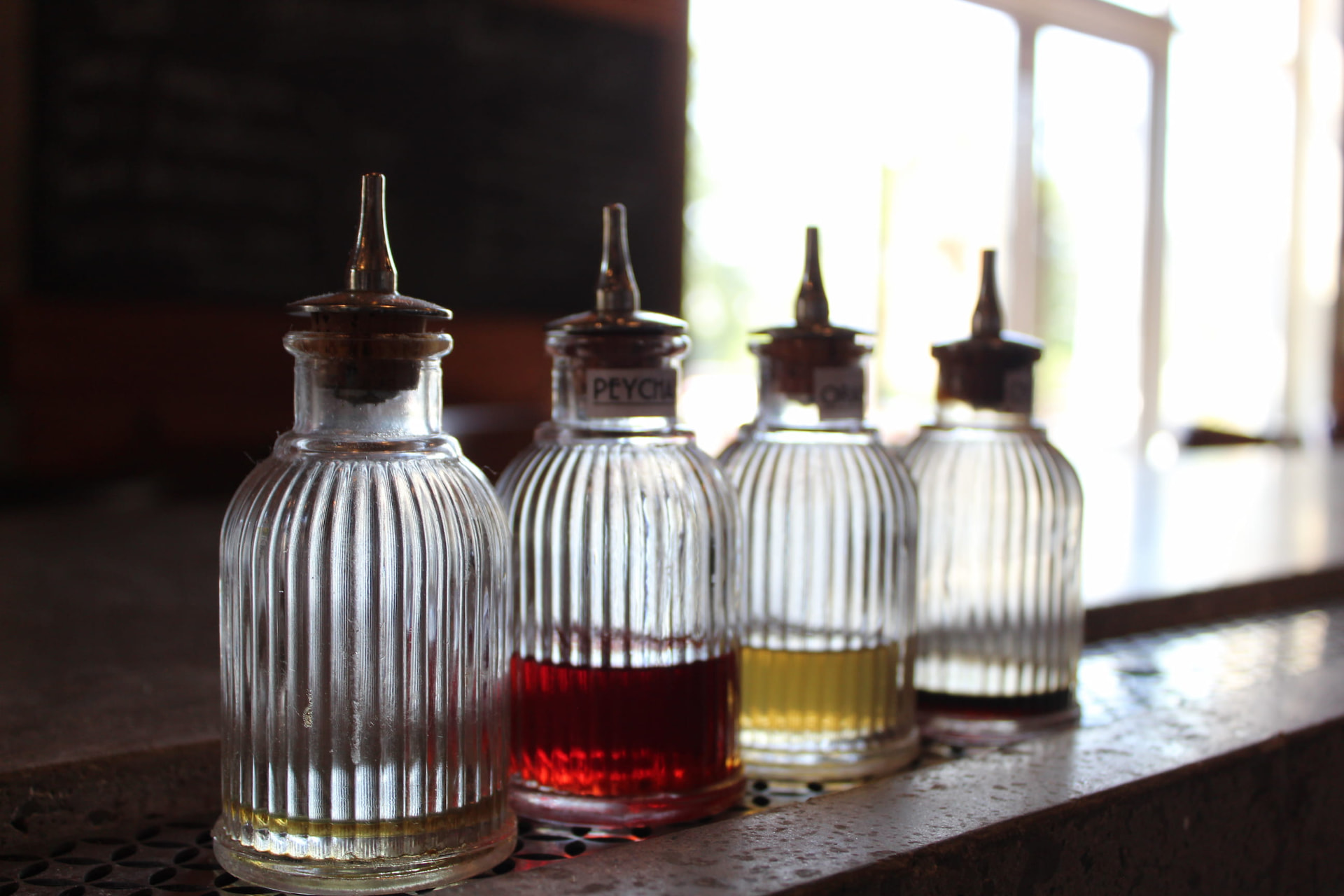 Vintage ribbed bitters bottles backlit on the Prophecy Social House bar