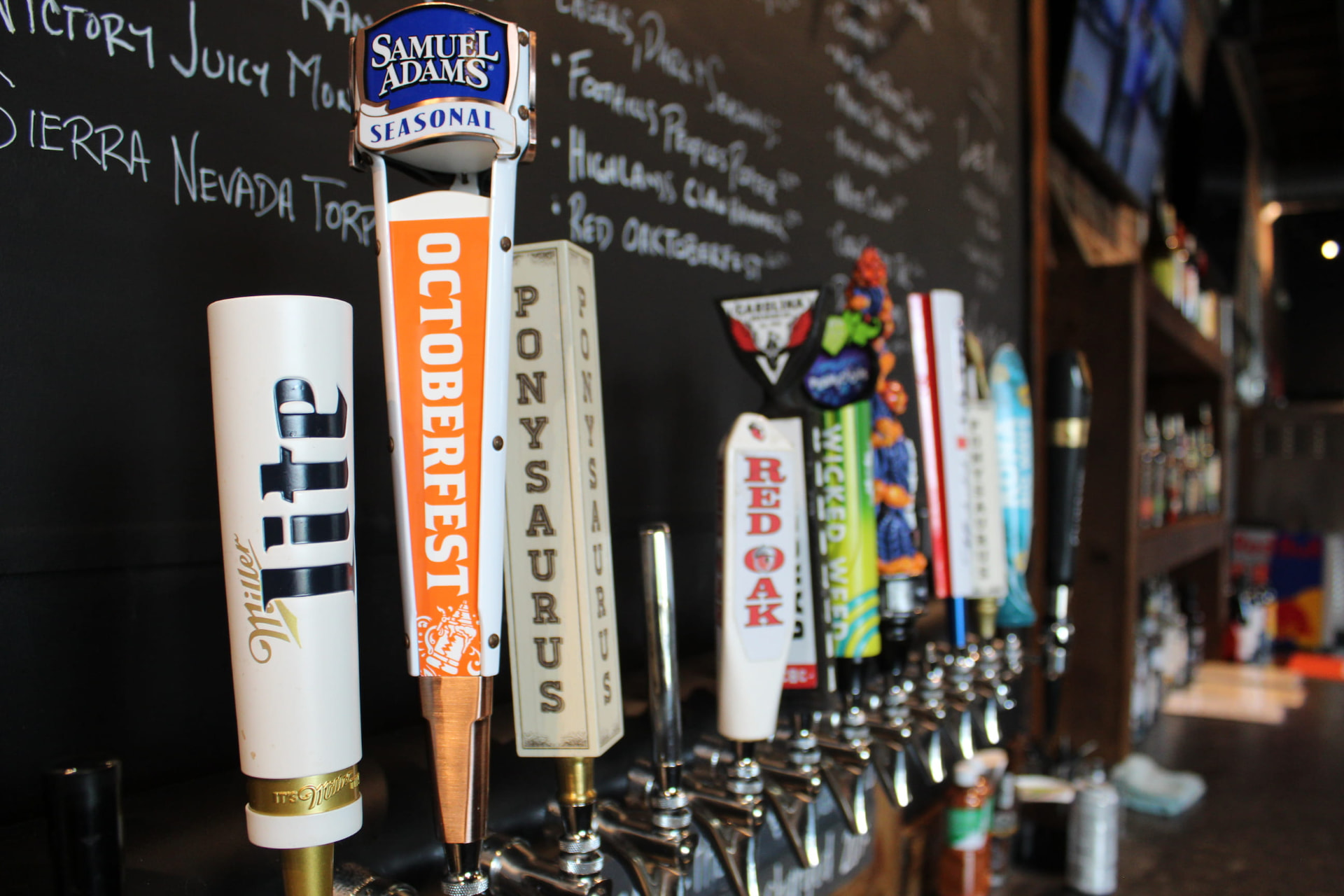 Colorful beer tap handles mounted above the chalkboard menu at Prophecy Social House