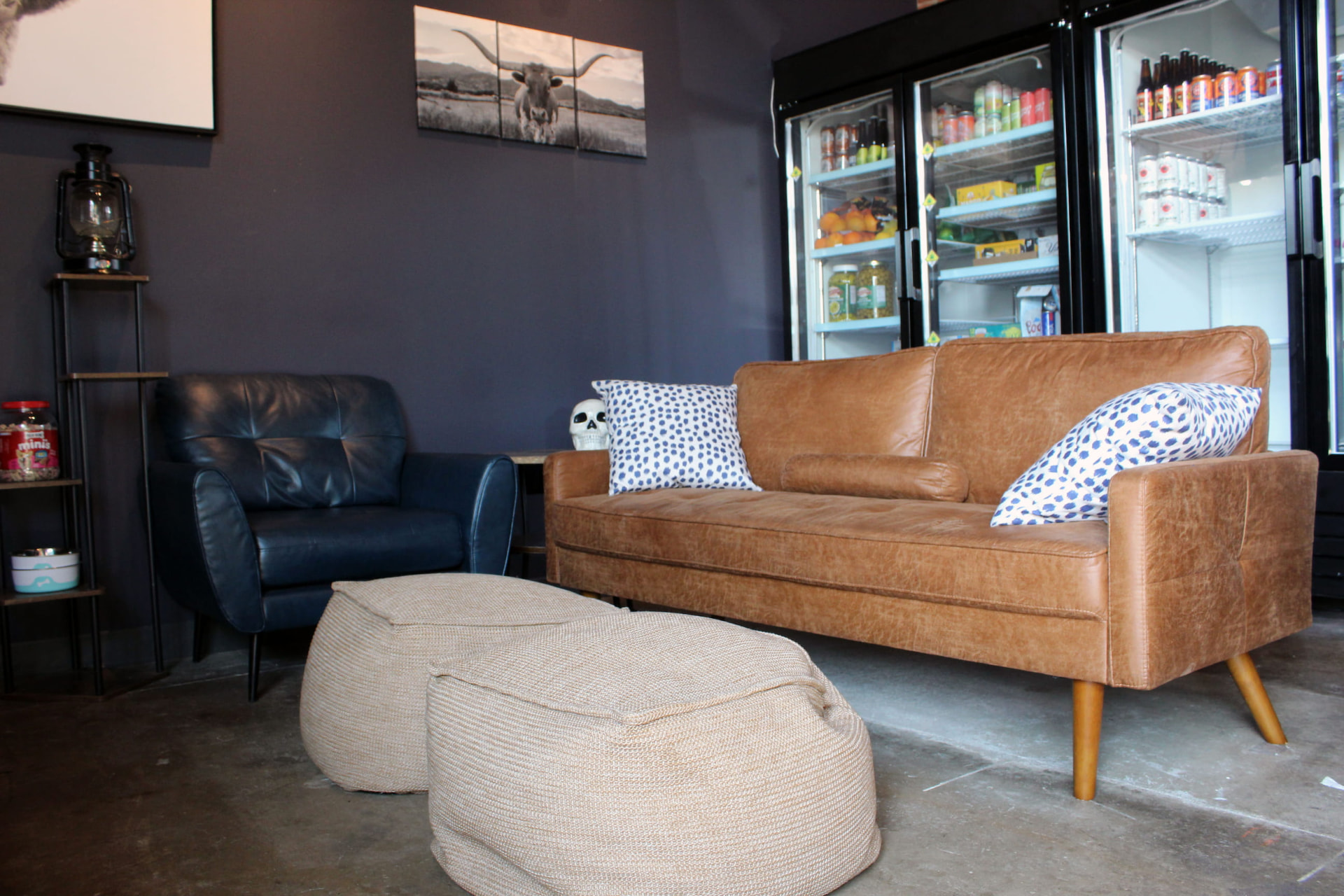 Lounge seating area with leather couches, chairs and cow print art at Prophecy Social House