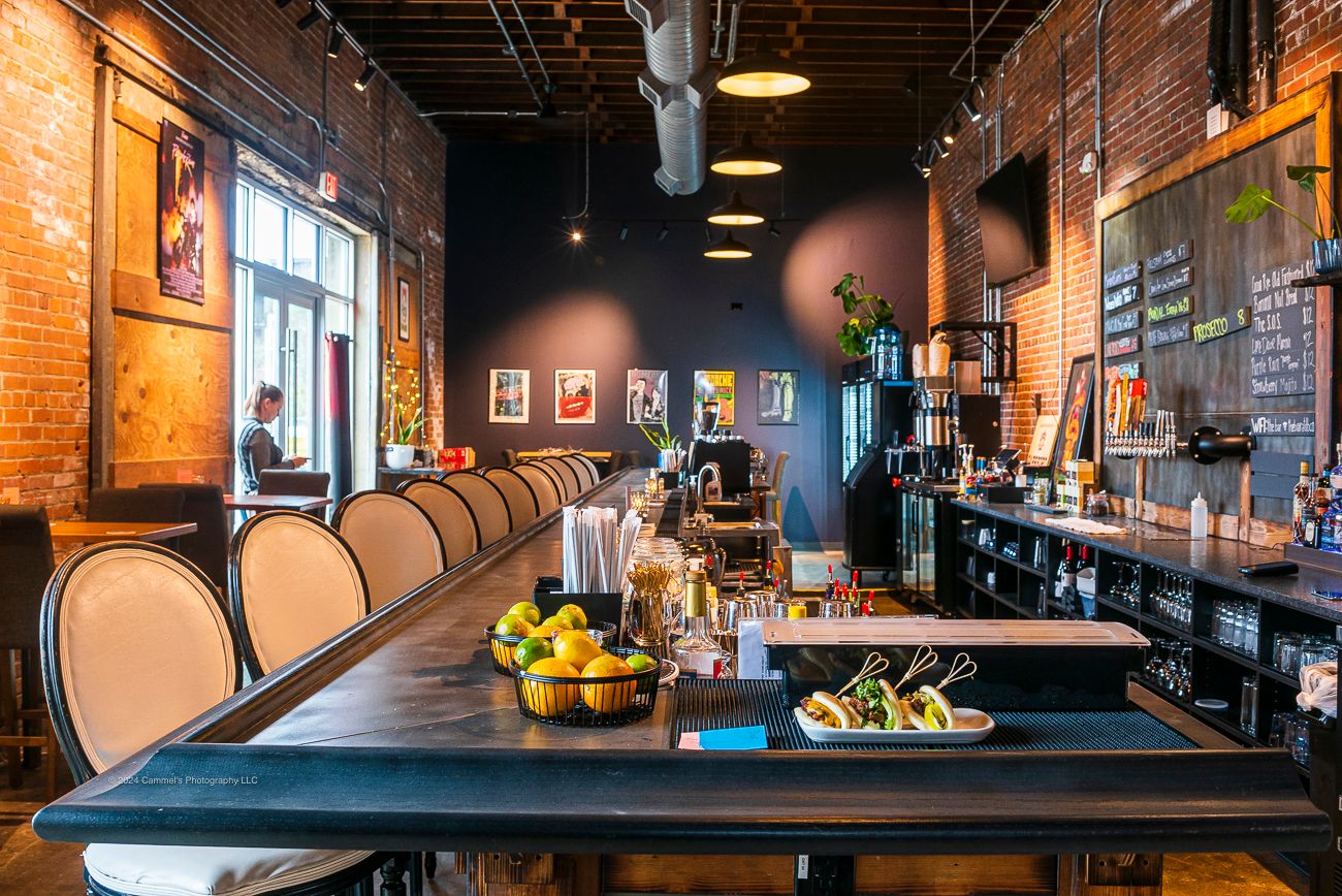 Looking down the length of the bar top, glassware and taps behind it